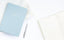 A blue gratitude journal sits on a white desk next to an open Ink+Volt Planner.