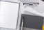 An assortment of tools for focus: a planner open to a weekly planning page, a notebook, pen, and glasses.