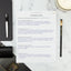 The Yearly Planning Worksheet Part 1 sits on a table next to a white pen and notepad.