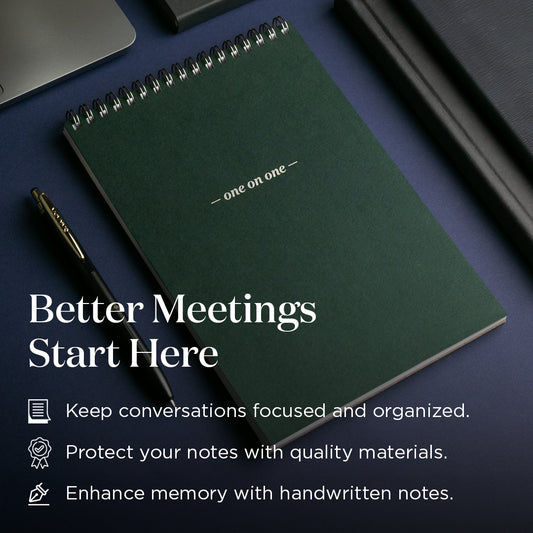 Green notebook with a pen on a dark surface, featuring text about better meetings and quality materials.