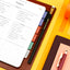 Packing list in a notebook with colorful tabs on a yellow background